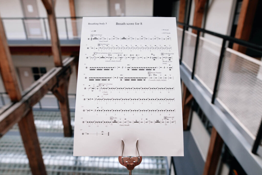 The music score for 'Breathing Backwards' sits on a music stand. It seems to be placed at the edge of a balcony. 